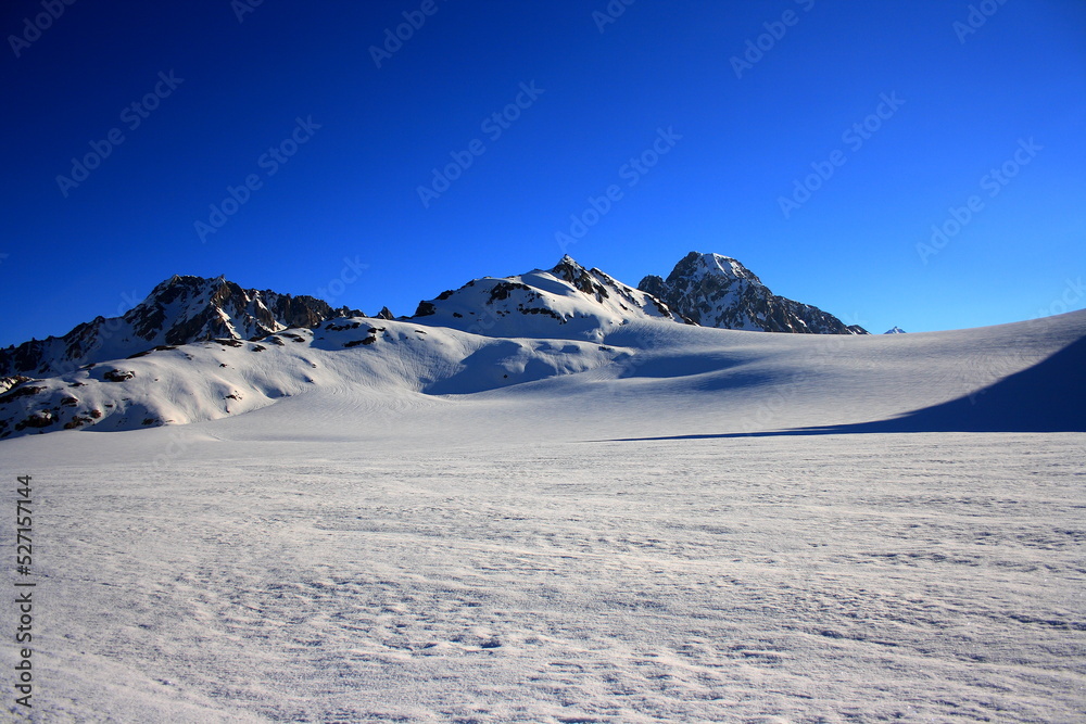 snow-covered mountain top, with a clear blue sky in the background