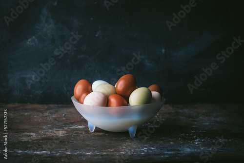 Mulit-colored eggs in glass bowl side angle