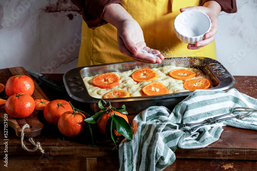 Sweet Focaccia with oranges,  woman preparing process photo