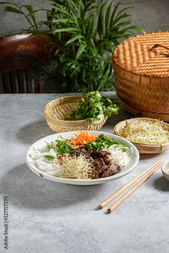 traditional Vietnamese noodle salad - Bun Bo Nam Bo, with beef, rice noodles, fresh herbs, pickled vegetables and fish sauce photo