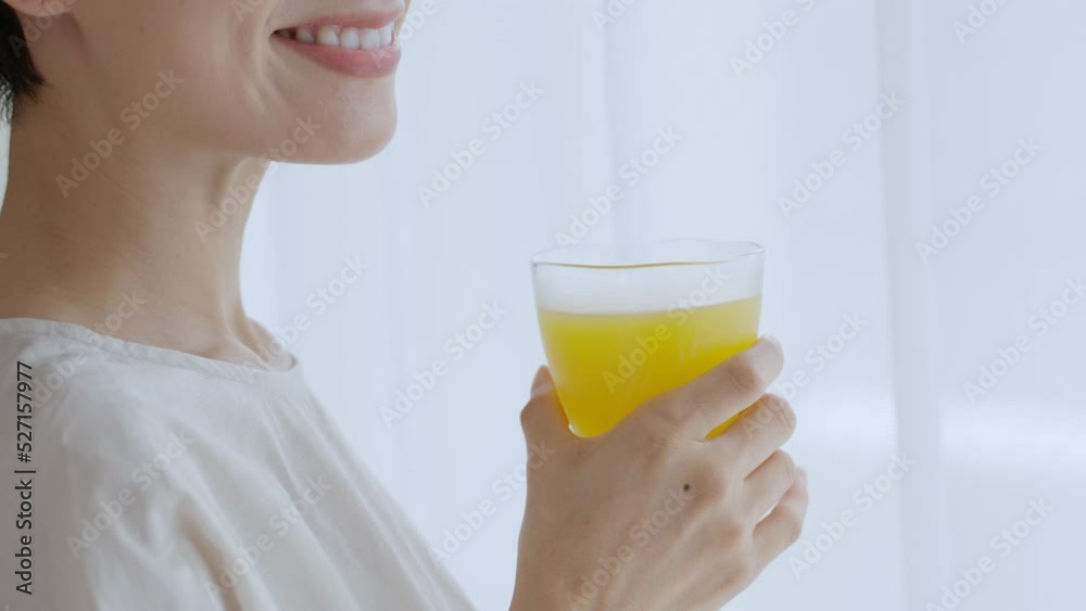 オレンジジュースを飲むミドル女性 オレンジジュースを飲むミドル女性