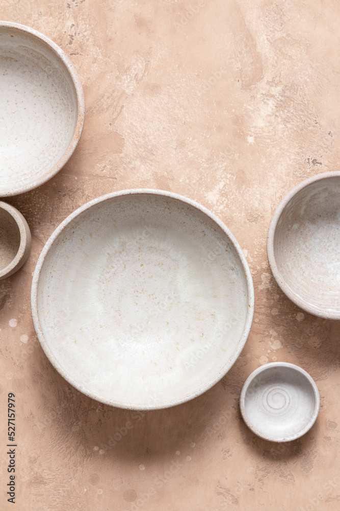 Five empty ceramic bowls on a pink background