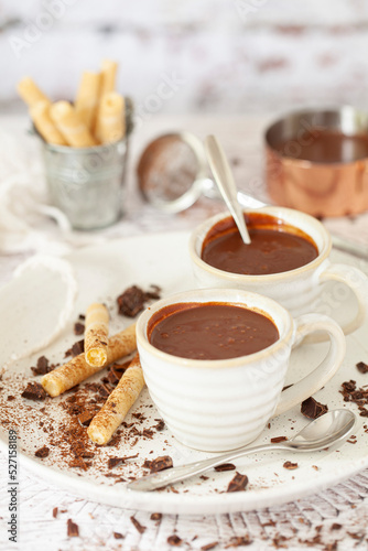 Italian style thick hot chocolate (cioccolata calda) in espresso cups with wafer cigars. photo