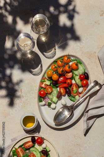 Summer Greek salad with hard light and white wine photo