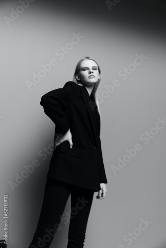 A concept for clothing brands. Cool offer banner for sale. A young lady model in a suit poses in the studio looking down into the camera