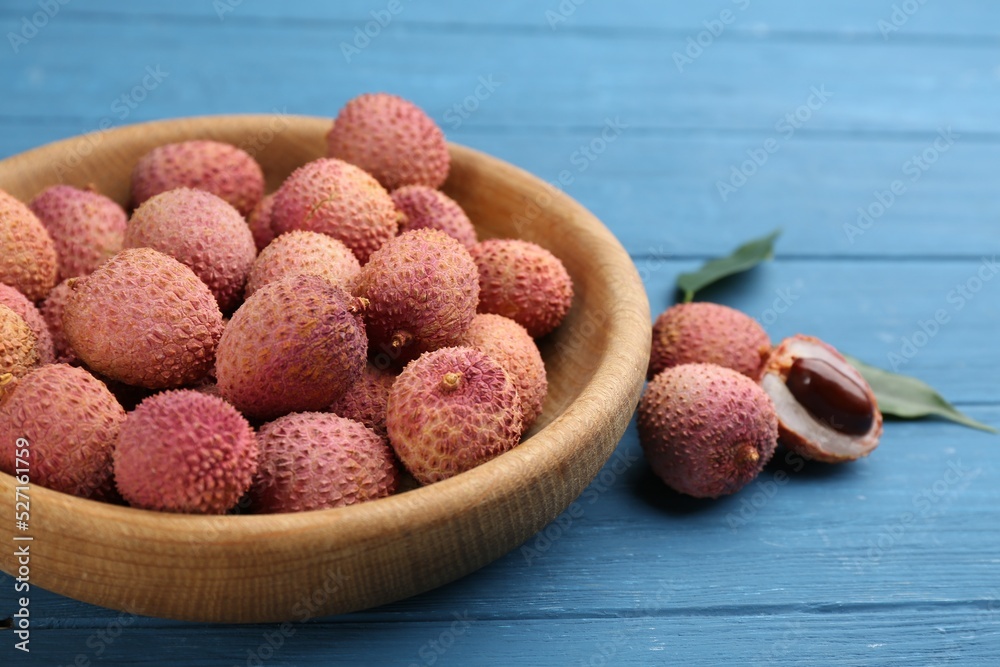 Fresh ripe lychee fruits on blue wooden table