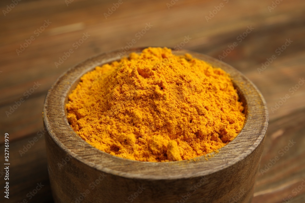 Aromatic saffron powder in bowl on wooden table, closeup Aromatic saffron powder in bowl on wooden table, closeup