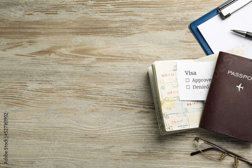 Moldova, Ceadir-Lunga - June 13, 2022: Flat lay composition with passports, pen and glasses on wooden table. Space for text photo