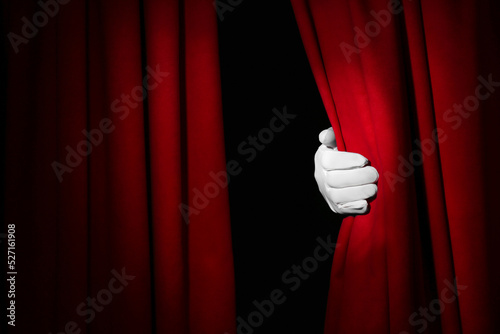 Person opening red front curtains on black background, closeup