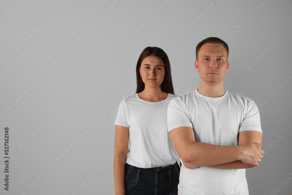 Portrait of young woman and man on light background. Space for text Portrait of young woman and man on light background. Space for text