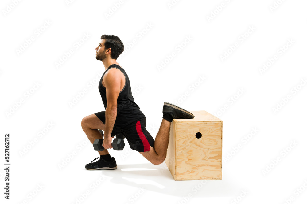 Attractive latin man using a plyo box to do leg lunges Attractive latin man using a plyo box to do leg lunges