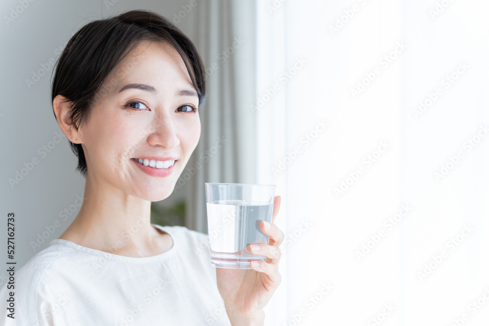 水の入ったコップを持った日本人女性