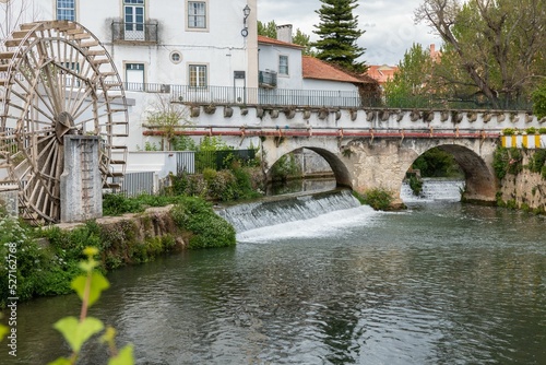 Old water wheel and the bridge by River Almonda in the old city of Torres Novas, Santarem, Portugal