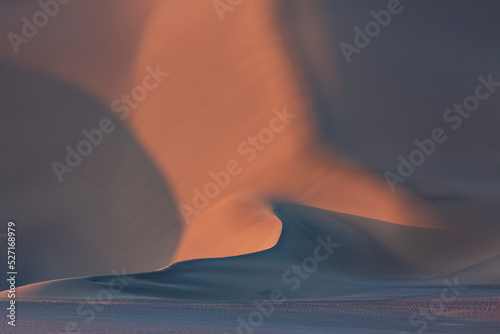 Sand dunes in sunset in desert, Xinjiang China, beautiful lines and texture, background material photo