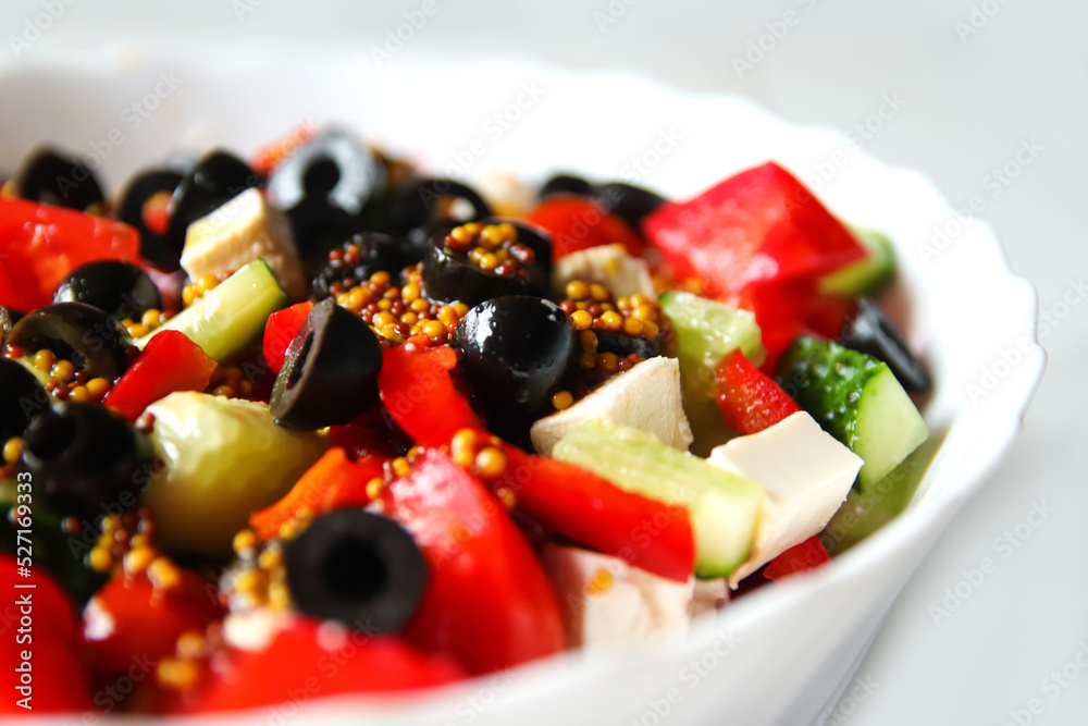 Defocus closeup summer salad. Classic Greek salad from tomatoes, cucumbers, red pepper, onion with olives, oregano and feta cheese. Fresh mixed vegetables salad in a bowl. Black olives. Out of focus Defocus closeup summer salad. Classic Greek salad from tomatoes, cucumbers, red pepper, onion with olives, oregano and feta cheese. Fresh mixed vegetables salad in a bowl. Black olives. Out of focus