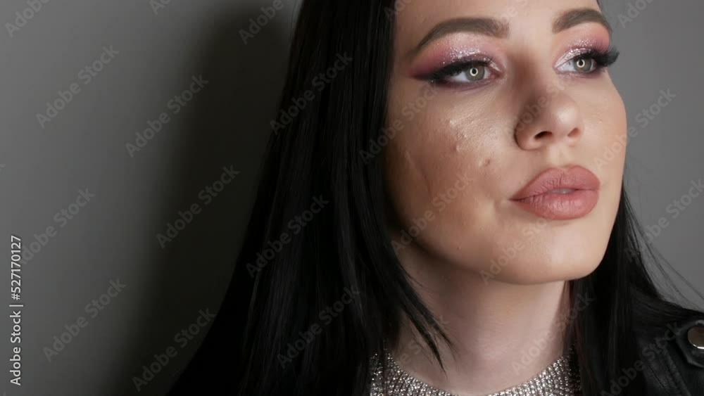 Young woman with beautiful bright evening make-up posing in studio