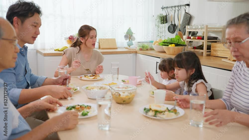 Asian big happy family have lunch on eating table together in house. 