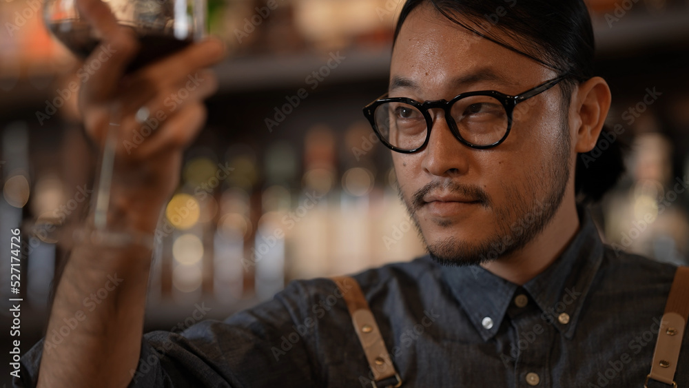 Night club concept of 4k Resolution. Asian man tasting wine in a restaurant. A group of specialized clubs that sell alcoholic beverages.