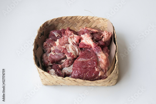 Lamb raw meat in the bamboo plate or besek at the Feast of Qurban during Eid Al Adha Al Mubarak isolated on white background. photo