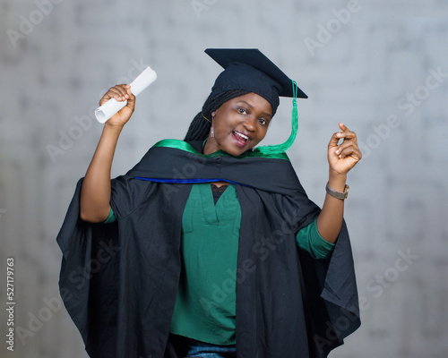 Foto Dancing portrait of an African female student or graduand from Nigeria, wearing