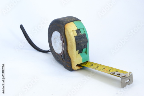 a used black, yellow, and green measuring tape isolated on white background, dirty measuring tape