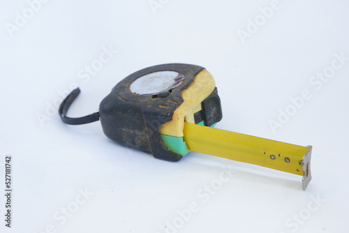 a used black, yellow, and green measuring tape isolated on white background, dirty measuring tape