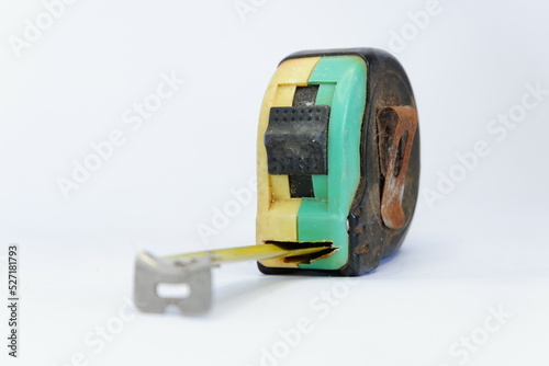 a used black, yellow, and green measuring tape isolated on white background, dirty measuring tape