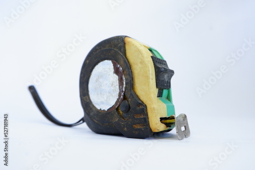 a used black, yellow, and green measuring tape isolated on white background, dirty measuring tape