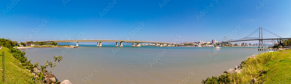 Fototapeta premium mar e céu azul e uma panorâmica das pontes de concreto e da ponte pênsil da cidade de Florianópolis, Santa Catarina, Brasil