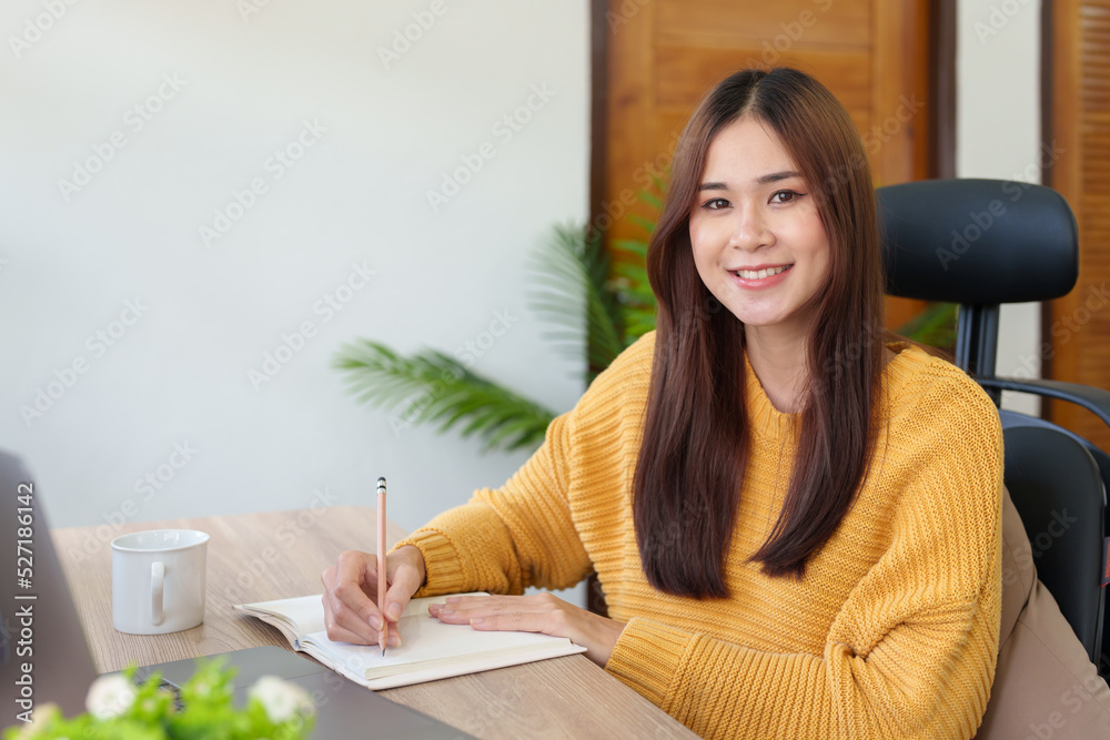 A woman using a pencil to write down memories in a notebook