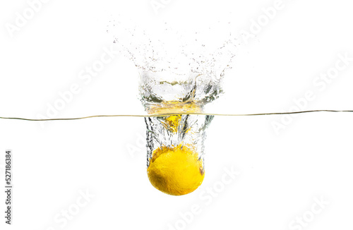 A lemon falling to the water with the splashing. Tasty and healthy meal.