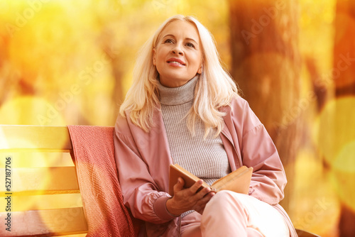 Mature woman with book on b...