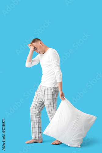 Sleepy young man with pillo...