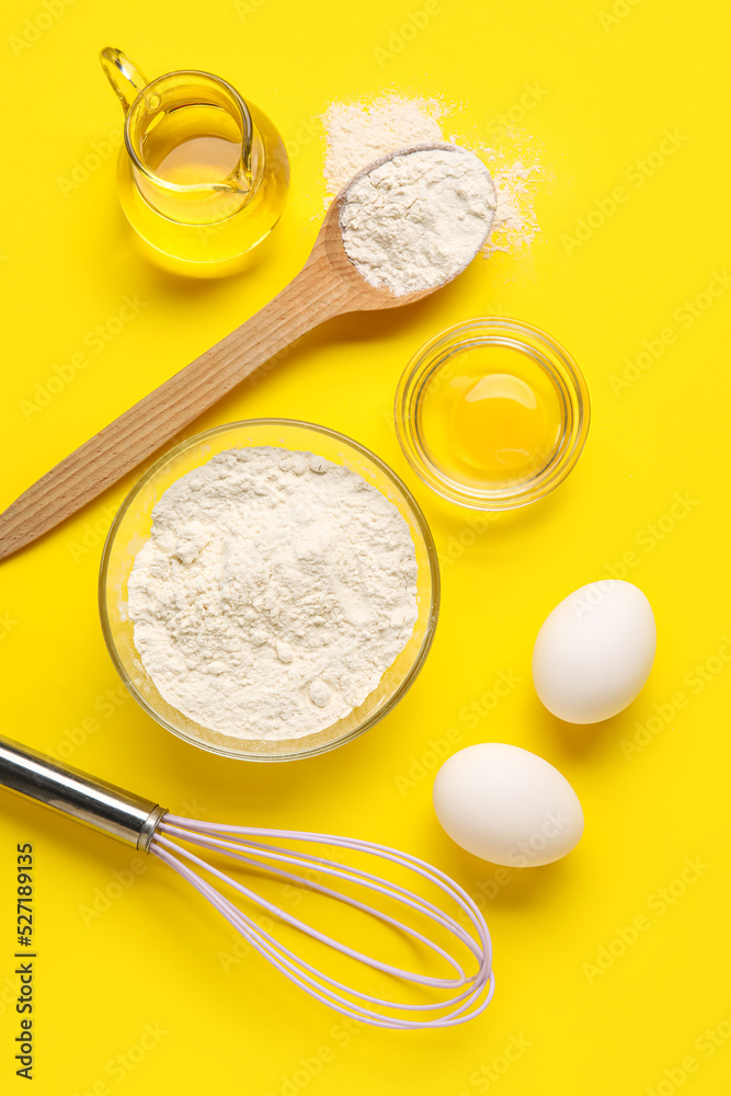 Composition with ingredients for baking and whisk on yellow background Composition with ingredients for baking and whisk on yellow background