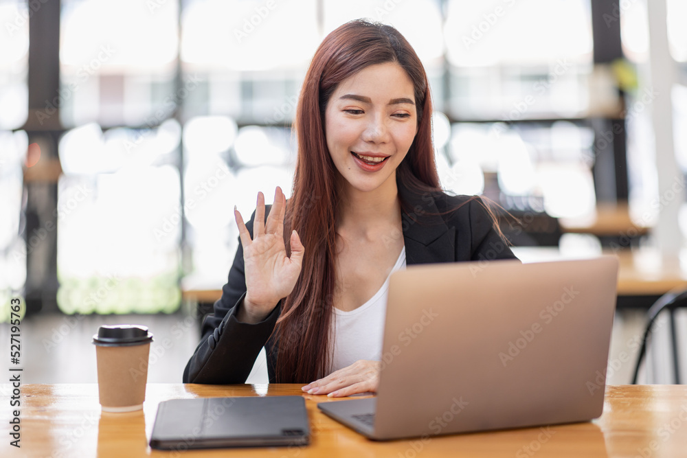 Young attractive Freelancer business asian woman talking about sale report in video call conference on laptop computer online meeting in the workplace, finance Work remotely Social isolation concept.