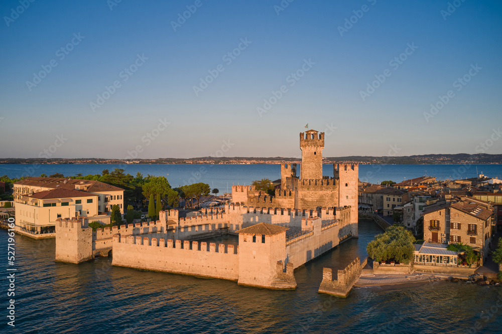 Historic part of the city of Sirmione view on Lake Garda, Italy. View of Scaligero Castle at sunrise. Historic Water Castle on Lake Garda.