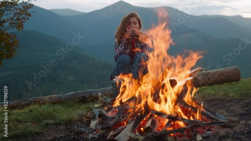 Closeup relaxed woman camping on nature. Tourist look bonfire in mountains trip.