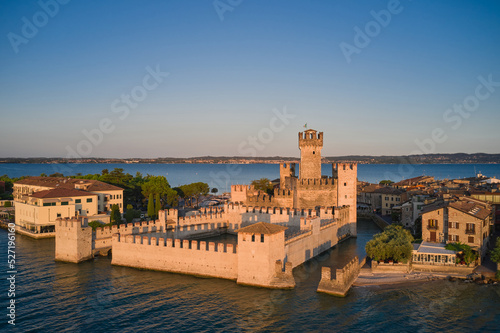 Historic part of the city of Sirmione view on Lake Garda, Italy. View of Scaligero Castle at sunrise. Historic Water Castle on Lake Garda.