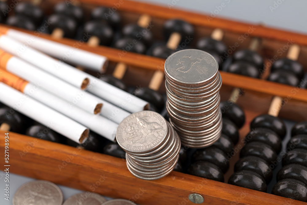 Naklejka premium Coins and cigarettes on a abacus