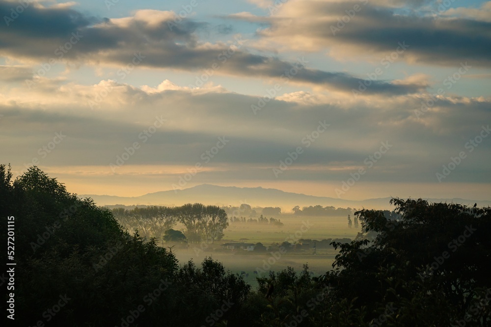 Rural Waikato, New Zealand. Beautiful warm sunrise with hills and paddocks.