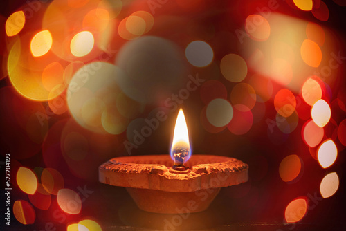 Happy Diwali. Diya lamp lit, dark bokeh light. Deepavali Hindu holiday celebration
