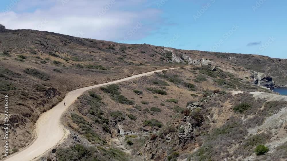 Solo Bicyclist riding dirt road on Catalina Island Backcountry California Solo Bicyclist riding dirt road on Catalina Island Backcountry California