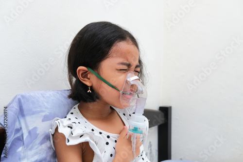 Asian kid in nebulizer treatment when suffering chest tightness