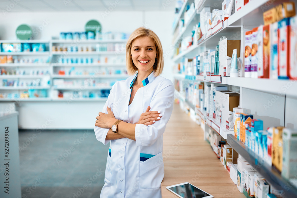 Happy pharmacist standing with her arms crossed in pharmacy and looking at camera. Happy pharmacist standing with her arms crossed in pharmacy and looking at camera.