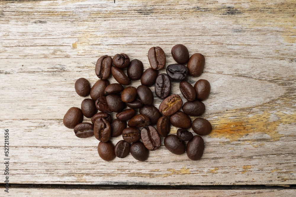 Coffee beans fall on rustic wooden table  Delicious luxury coffee beans and the aroma of morning coffee.