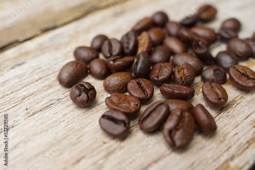 Coffee beans fall on rustic wooden table Delicious luxury coffee beans and the aroma of morning coffee.