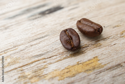 Coffee beans fall on rustic wooden table Delicious luxury coffee beans and the aroma of morning coffee.