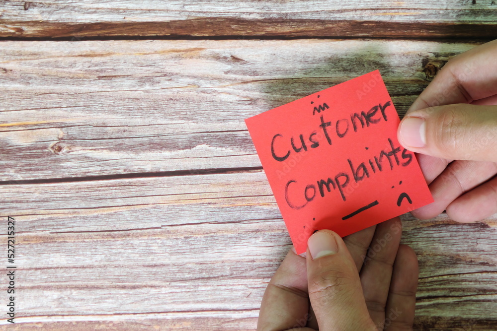 How to handle customer complaint concept. Hand holding red note with written word complaints with copy space.