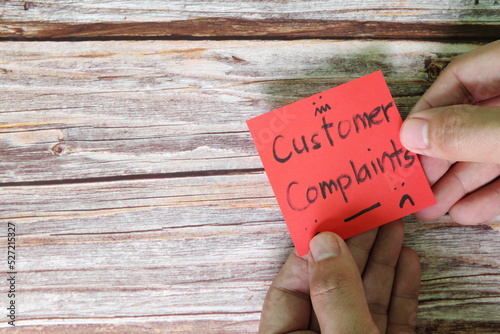 How to handle customer complaint concept. Hand holding red note with written word complaints with copy space. photo