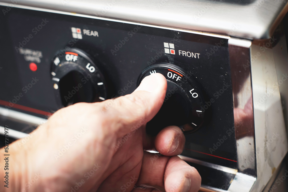 Person turning on knob on stove Stock Photo Adobe Stock